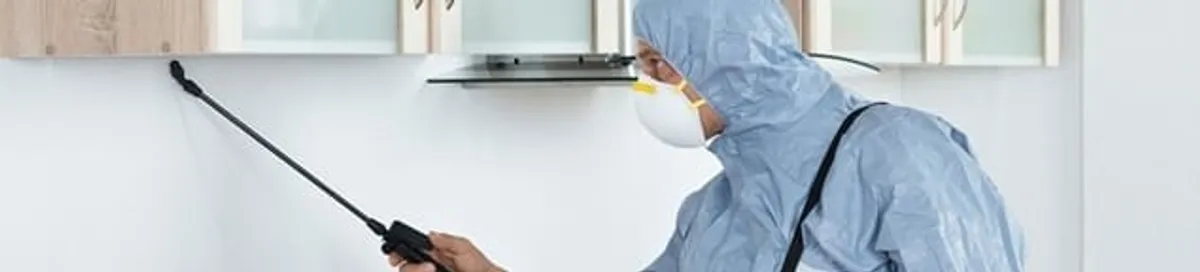 Termite treatment technician applying indoor pest control spray in Anchorage, AK