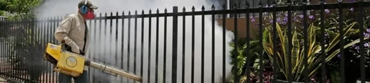 Mosquito control technician fogging a yard perimeter for mosquito reduction in Anchorage, AK